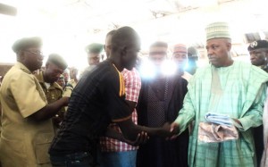 PIC. 13. GOV. KASHIM  SHETTIMA (R) OF BORNO, PRESENTING NEW CLOTHINGS TO ONE OF  THE 22 PRISONERS PARDONED BY THE STATE DURING HIS VISIT TO THE MAIDUGURI MAXIMUM PRISON ON WEDMESDAY (1/10/14). 
