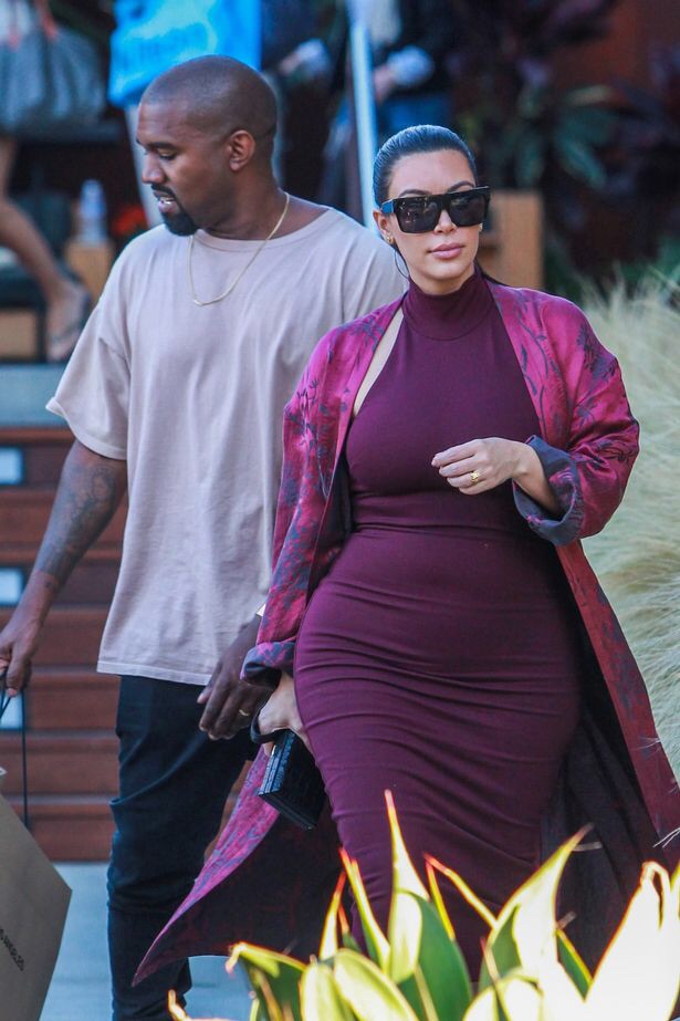 Pregnant Kim Kardashian carries daughter North as she shows off bump